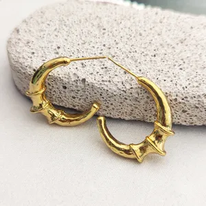 Boucles d'oreilles croissant bambou dorées vue détaillée au design minimaliste élégant.