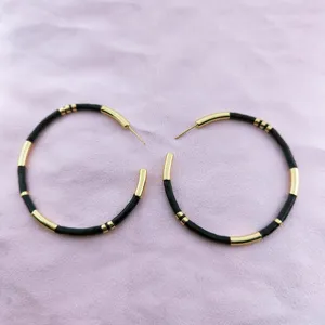 Boucles d'oreilles créoles bambou noir et or, bijoux tendance élégants pour femmes.