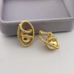 Boucles d'oreilles en metal dore vintage avec design en fil enroule et sphere pour femmes.