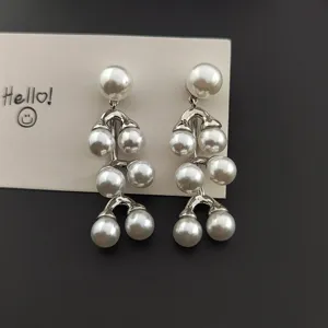 Gros plan de boucles d'oreilles à pampilles de perles multicouches, métal argenté.