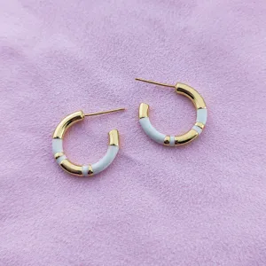 Créoles en bambou émaillé blanc plaqué or pour femmes, détails de bijoux de créateurs chics.