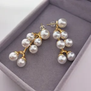 Élégantes boucles d'oreilles pendantes en perles dorées bijoux de mode stylés.