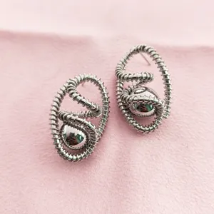 Gros plan de boucles d'oreilles spirale en métal exquises, bijoux de style rétro avant-garde.