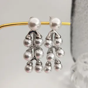 Gros plan détaillé de boucles d'oreilles à pampilles de perles multicouches en métal argenté.