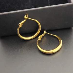 Créoles dorées classiques pour femmes, design rond élégant et minimaliste, bijoux de tous les jours.