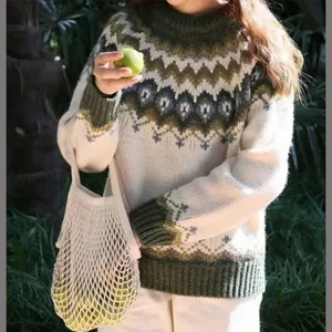 Detailed shot of women's green white colorblock crewneck knit sweater with nordic pattern.