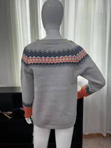 Detailansicht des grauen Pullovers mit bunten geometrischen Mustern an Passe und Bündchen.