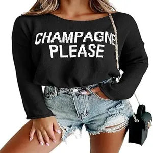 Close-up detail of the black knit sweater featuring white letter knitwear and round neckline style.