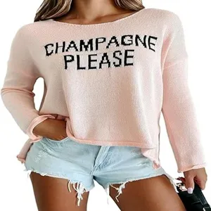 Close-up detail of the pink knit sweater featuring bold black slogan knit lettering.