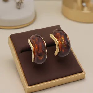 Boucles d'oreilles vintage en resine ambre doree forme C, bijou elegant style francais.