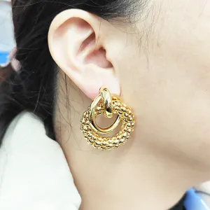Boucles d'oreilles creoles texturees entrelacees plaquees or, bijoux de mode minimalistes.