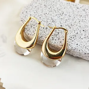 Elegantes creoles dorees en forme de U avec pendentifs en cristal transparent de mode.