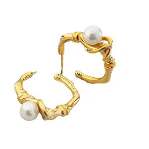 Boucles d'oreilles géométriques en métal torsadé doré vintage avec perle blanche élégante.
