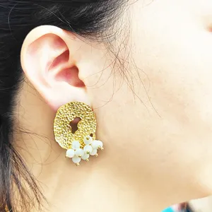 Boucles d'oreilles pendantes texturées dorées avec perles blanches style élégant femme