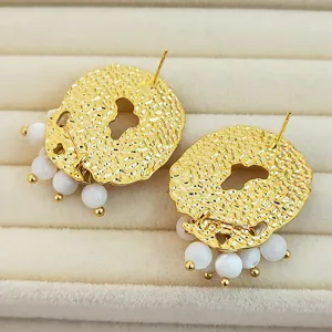 Boucles d'oreilles rondes irrégulières texturées plaquées or avec perles de coquillage blanc.