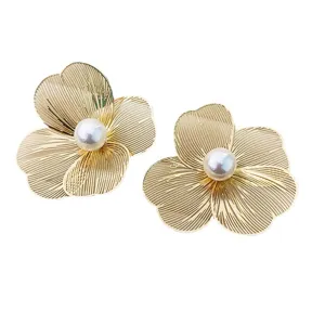 Élégantes boucles d'oreilles à fleurs ajourées avec perle centrale, design chic pour femmes.