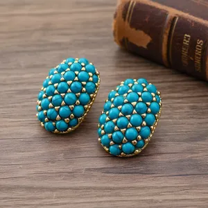 Boucles d'oreilles vintage ovales en turquoise avec sertissage doré, détail élégant.