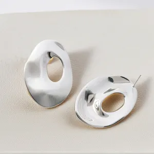 Gros plan de boucles d'oreilles géométriques irrégulières minimalistes argentées, design élégant.
