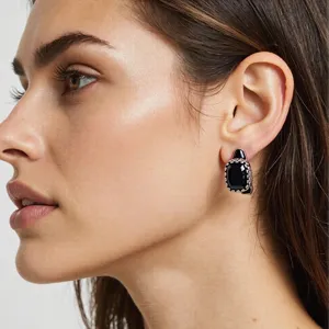 Boucles d'oreilles clous vintage en argent avec une pierre noire et des bordures perlées.