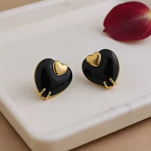 Élégantes boucles d'oreilles cœur noir et or pour femmes, bijoux design chic tendance.