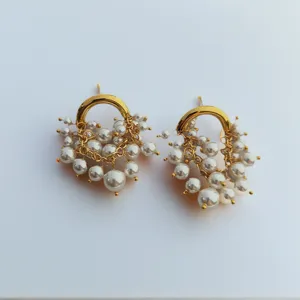 Gros plan de boucles d'oreilles grappe de perles vintage avec anneau dore elegant.