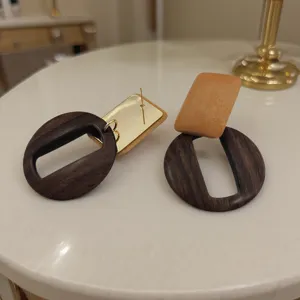 Boucles d'oreilles géométriques en bois minimalistes avec accent métal look rétro chic.