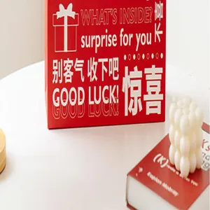Rote Valentinstag Geschenkverpackung mit romantischer Typografie und weißer Kerzendekoration.