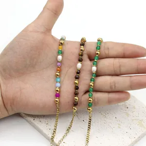 Close-up of freshwater pearl and natural stone beaded bracelets shown in a hand