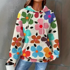 Vista detallada de sudadera con capucha floral para mujer con tejido texturizado.