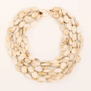 Macro detail view of a multi-layer marbled cream acrylic beaded necklace with gold hardware.