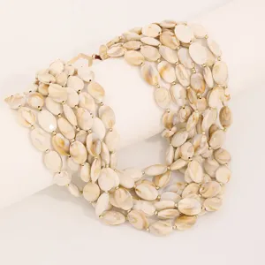Detailed view of multi-layer acrylic disc necklace with marble texture and gold beads