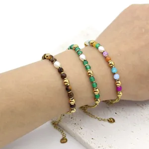 Stack of three natural stone and freshwater pearl beaded bracelets on a model wrist