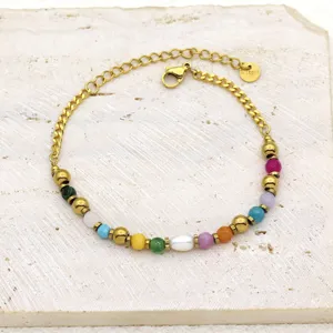 Detail of a titanium steel bracelet featuring colorful natural stones and a freshwater pearl.