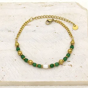 Detailed view of golden titanium steel bracelet with green stones and a freshwater pearl