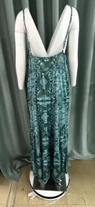 Vista posteriore di un abito lungo boho verde con stampa paisley su un manichino bianco