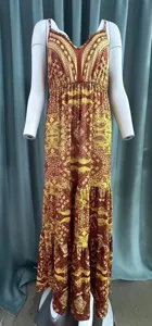 Dettaglio ravvicinato di un abito lungo stile boho con scollo a V e motivi floreali ricchi.