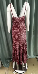 Dettaglio posteriore di un abito lungo boho bordeaux con stampa paisley su manichino