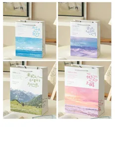 Primer plano detallado de bolsas de regalo de papel paisajísticas con citas artísticas.