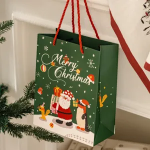 Gruene Weihnachtspapiertuete mit niedlichem Weihnachtsmann Motiv fuer Feste Geschenke