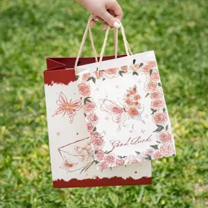 Bonita bolsa de regalo de papel con rosas y mariposas, embalaje de cartón grueso para obsequios.