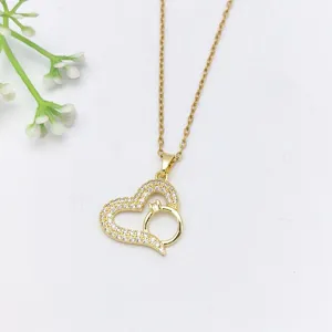 Primo piano dettagliato di una elegante collana con ciondolo a cuore dorato e zirconi.