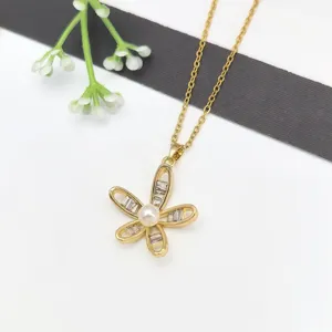 Collana con ciondolo a fiore dorato con zircone e perla, catenina clavicolare minimalista.