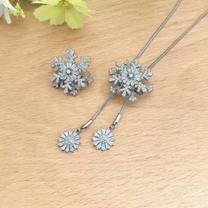 Gedetailleerd uitzicht op de sprankelende sneeuwvlok trui ketting en broche, elegante winter.