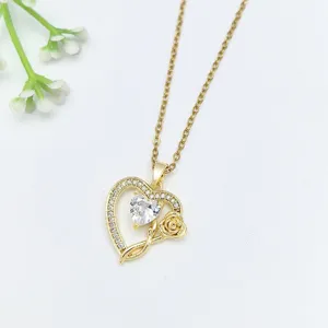 Dettaglio in primo piano della delicata collana con ciondolo a cuore dorato e zirconi luminosi.