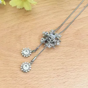 Detailweergave van de roterende sneeuwvloktruiketting en broche met sprankelende kristalaccenten.
