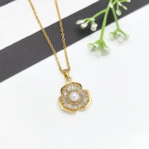 Dettaglio collana fiore oro con perla centrale e pietre di zircone scintillanti.