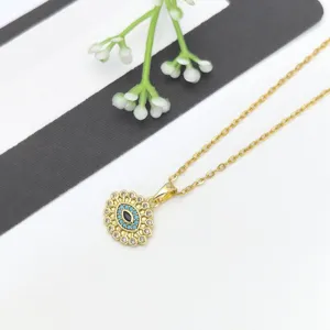 Primo piano dettagliato di una delicata collana con ciondolo dorato e zirconi luminosi.