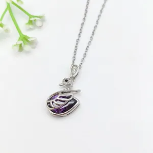 Dettaglio in primo piano della collana con cigno in cristallo viola e zircone pavimentato.