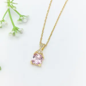 Dettaglio della collana in zircone dorato con ciondolo quadrato rosa per donne eleganti.