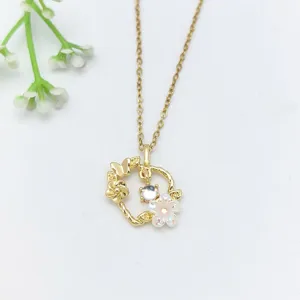 Primo piano dettaglio della collana con ciondolo fiore e farfalla dorata con zirconi.